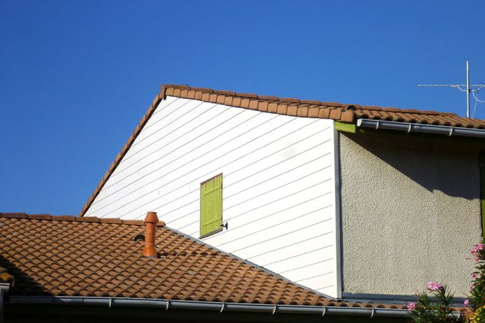 Pose d'un bardage en PVC blanc sur le côté nord d'une maison près de Toulouse